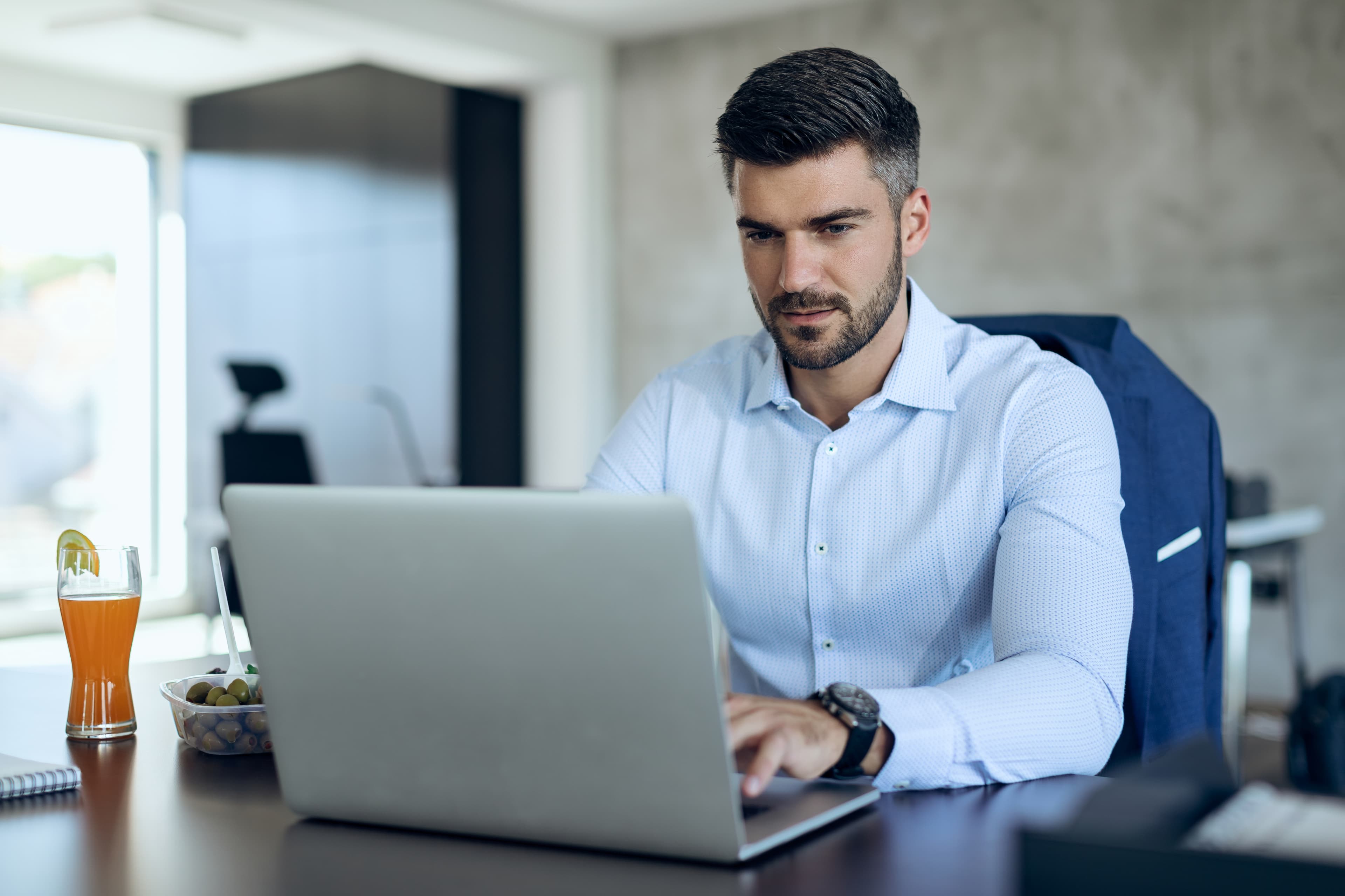Un entrepreneur professionnel travaillant sur son ordinateur dans un bureau moderne